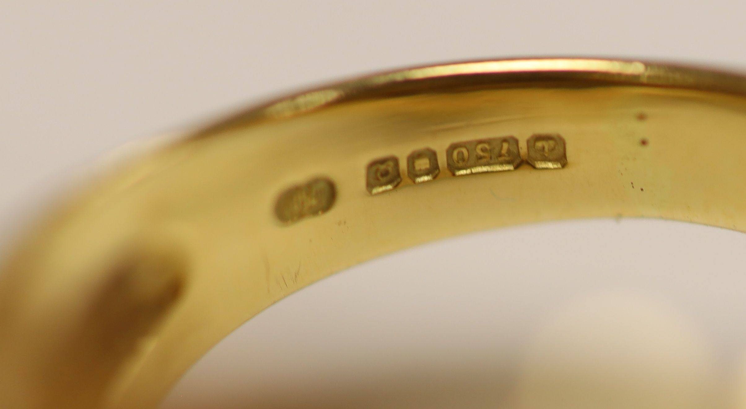 An early 1990's Cartier 18ct gold, black onyx and emerald set twin leopard's head crossover ring
